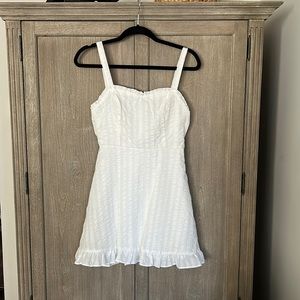 White feminine seersucker dress with ruffle accents. Never worn, but no tags.